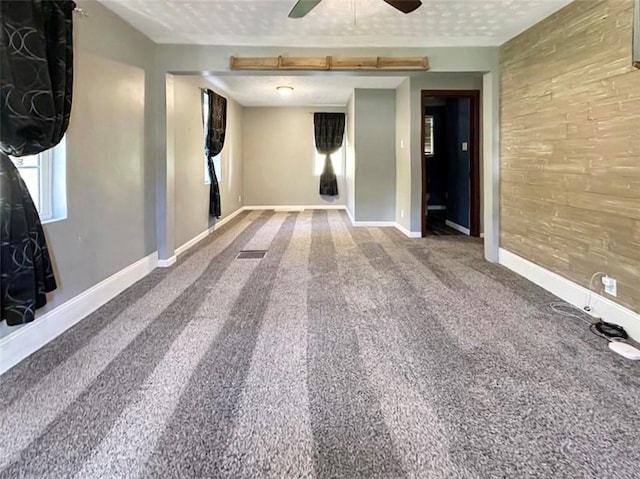 carpeted empty room with ceiling fan and a textured ceiling