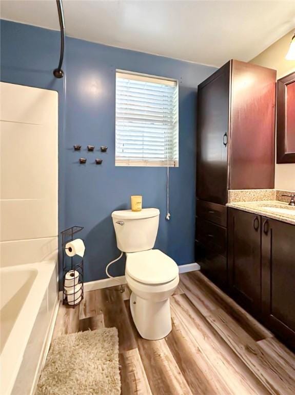 full bathroom with vanity, hardwood / wood-style flooring, toilet, and  shower combination