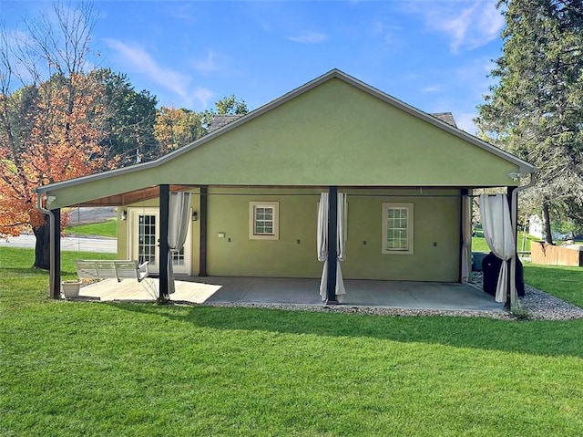 rear view of house with a yard and a patio