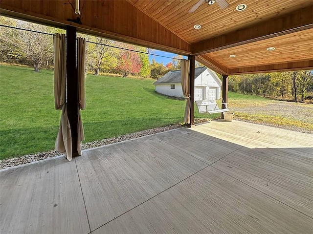 deck with ceiling fan, a yard, and a storage shed