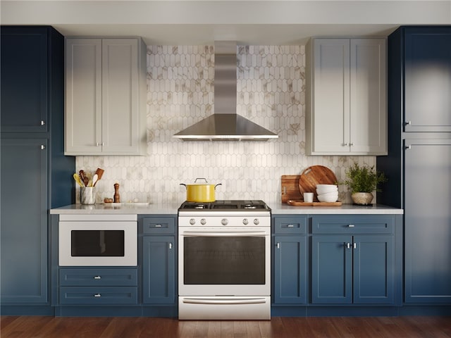 kitchen with blue cabinetry, dark hardwood / wood-style flooring, range with gas stovetop, decorative backsplash, and wall chimney range hood