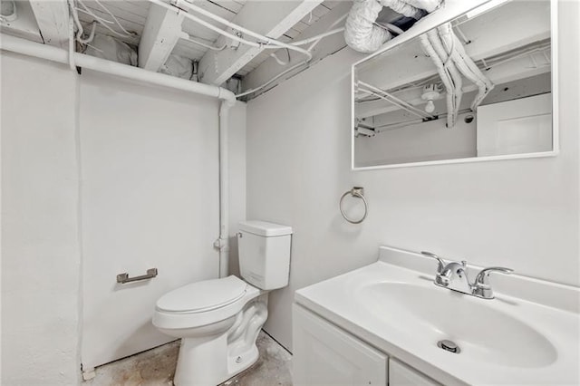 bathroom with vanity, concrete flooring, and toilet