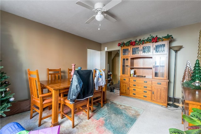 dining space with light colored carpet and ceiling fan