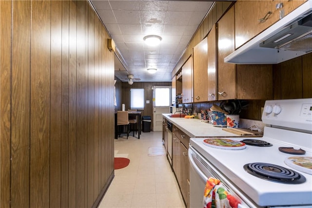 kitchen with electric range, ceiling fan, dishwasher, and wooden walls