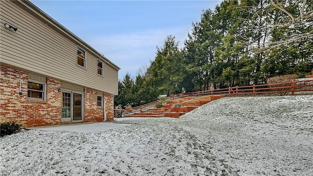 yard covered in snow featuring a patio