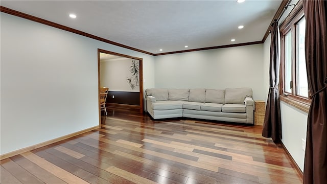 living room with crown molding, hardwood / wood-style floors, and a healthy amount of sunlight