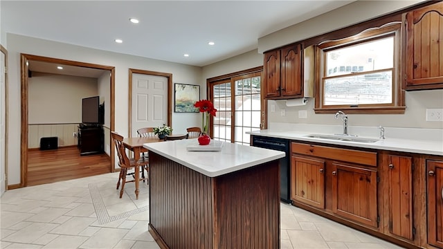 kitchen with dishwasher, a kitchen island, and sink