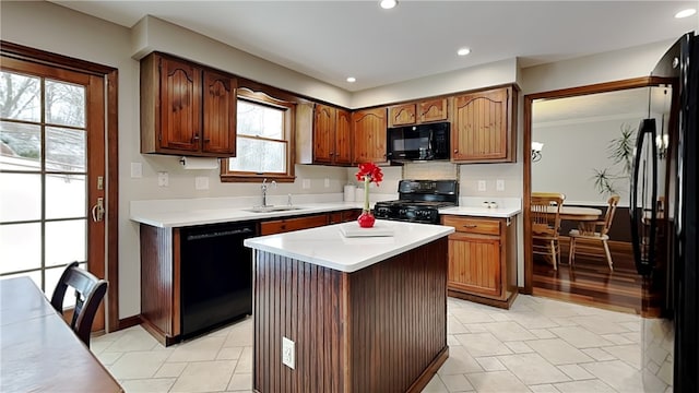 kitchen with black appliances, a center island, and sink