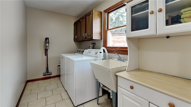 washroom with sink, light tile patterned floors, cabinets, and independent washer and dryer