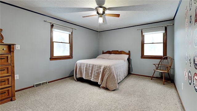 bedroom with ceiling fan, crown molding, and carpet