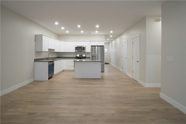 kitchen with stainless steel appliances, light wood-type flooring, a sink, and recessed lighting