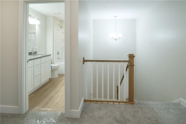 stairway with baseboards and a chandelier