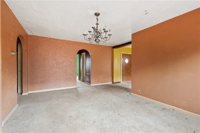 unfurnished room featuring an inviting chandelier