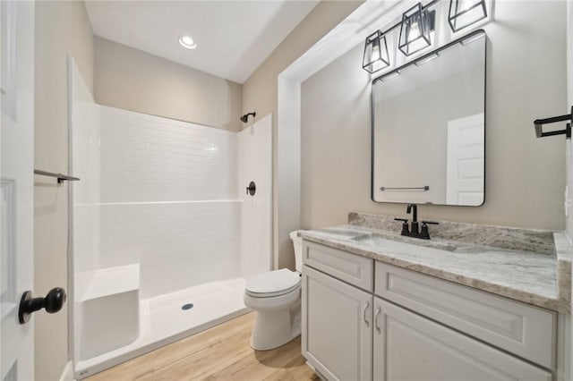 bathroom with vanity, hardwood / wood-style flooring, toilet, and walk in shower