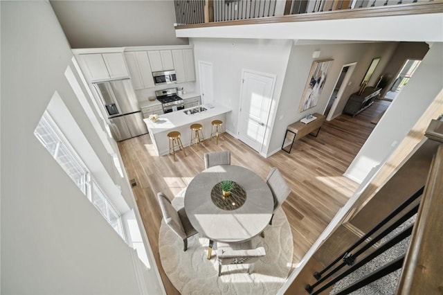 interior space with a towering ceiling, light wood-type flooring, and a wealth of natural light