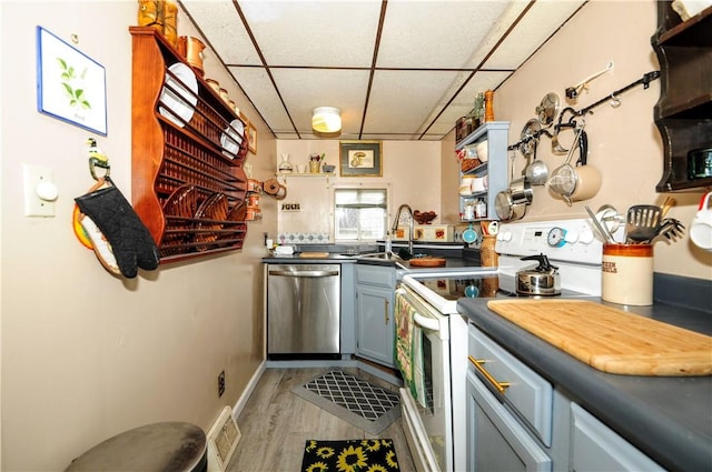 kitchen with a drop ceiling, white range with electric cooktop, sink, stainless steel dishwasher, and gray cabinets