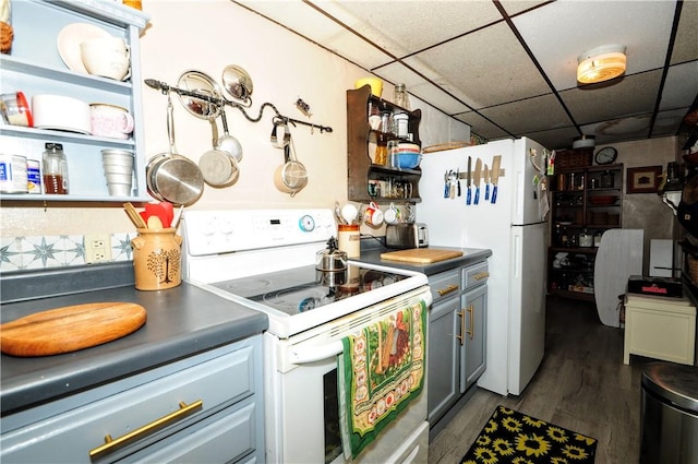 kitchen featuring dark hardwood / wood-style flooring, a drop ceiling, and white appliances