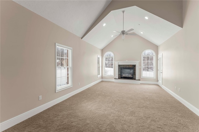 unfurnished living room with carpet flooring, ceiling fan, a premium fireplace, and vaulted ceiling