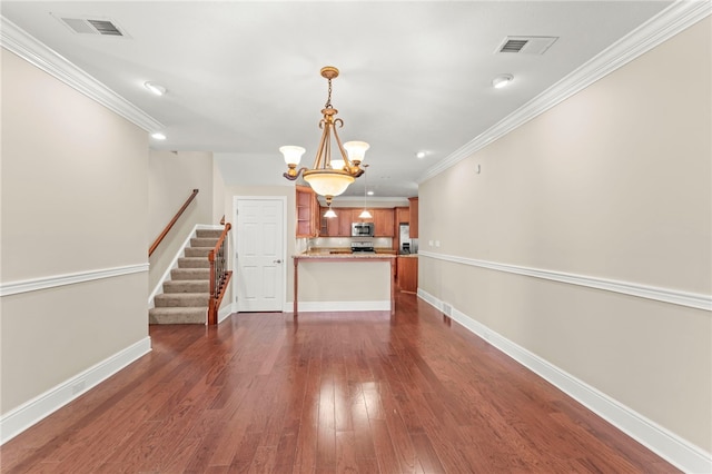 unfurnished living room with crown molding, dark hardwood / wood-style flooring, and a chandelier