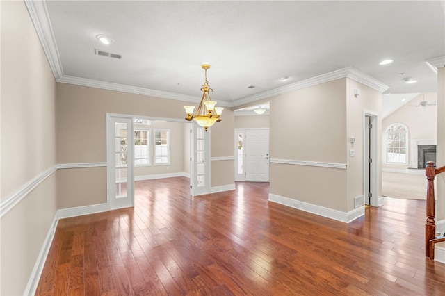 unfurnished room with hardwood / wood-style floors, ceiling fan with notable chandelier, and ornamental molding