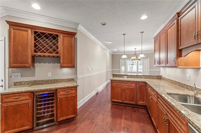 kitchen featuring ornamental molding, hanging light fixtures, beverage cooler, and sink