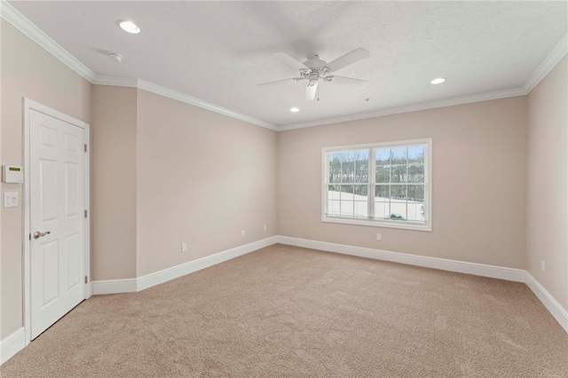 carpeted spare room with ceiling fan and ornamental molding