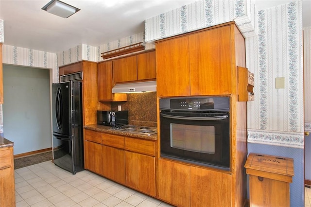 kitchen with black appliances, light tile patterned floors, and tasteful backsplash