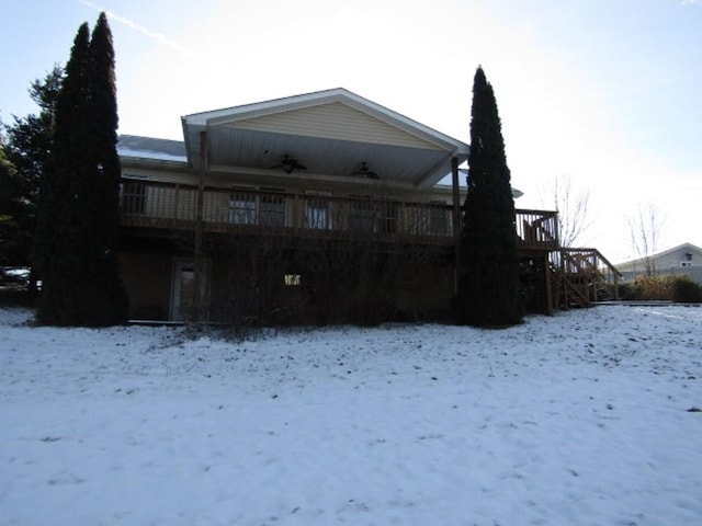 snow covered rear of property featuring a deck and ceiling fan