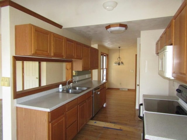 kitchen with sink, hanging light fixtures, dark wood-type flooring, an inviting chandelier, and stainless steel dishwasher