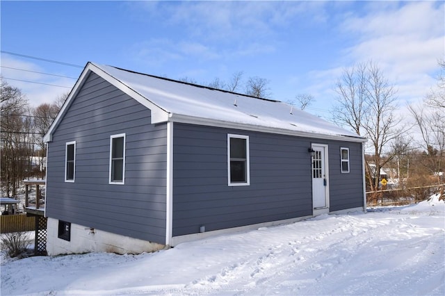 view of snow covered back of property