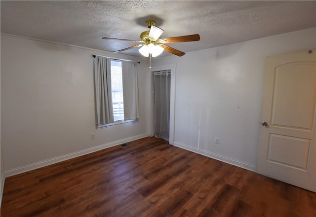 unfurnished room featuring ceiling fan, dark hardwood / wood-style flooring, and a textured ceiling