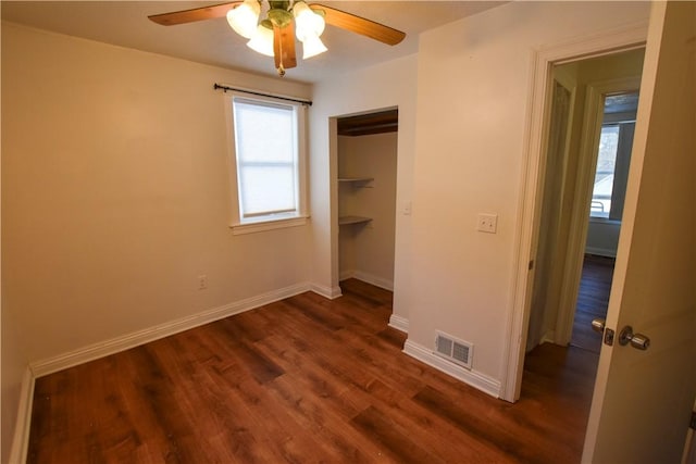 unfurnished bedroom featuring ceiling fan, dark wood-type flooring, and a closet