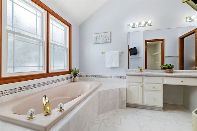 bathroom with tile patterned floors, tiled tub, vanity, and lofted ceiling