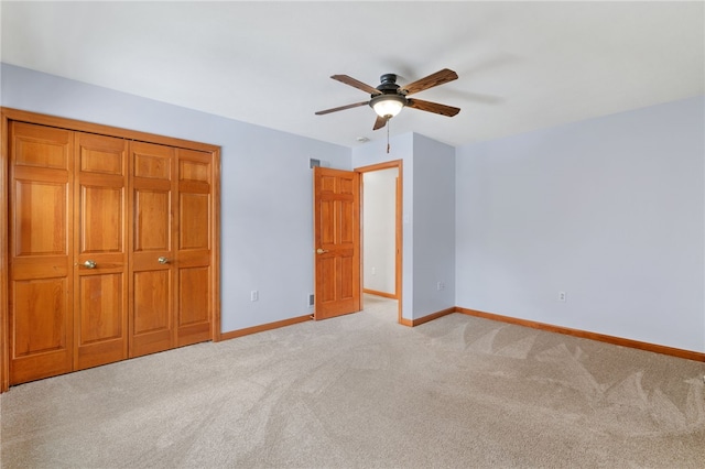 unfurnished bedroom featuring ceiling fan, light colored carpet, and a closet