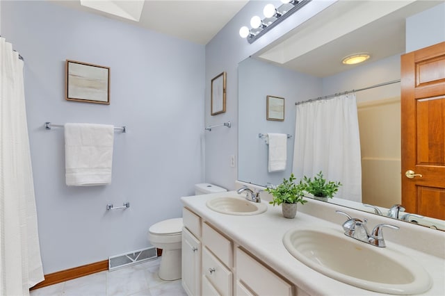 bathroom with tile patterned flooring, vanity, and toilet