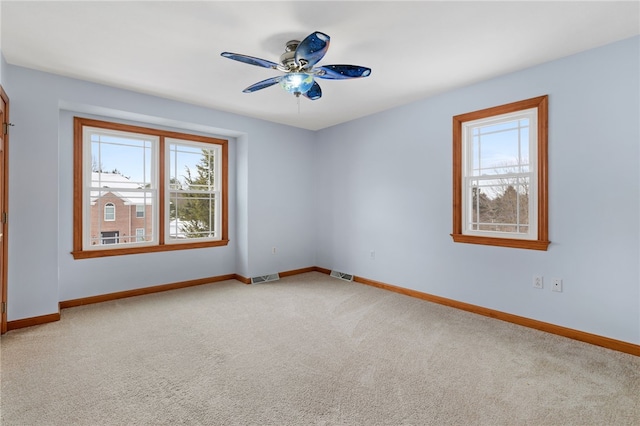 empty room with ceiling fan and light carpet