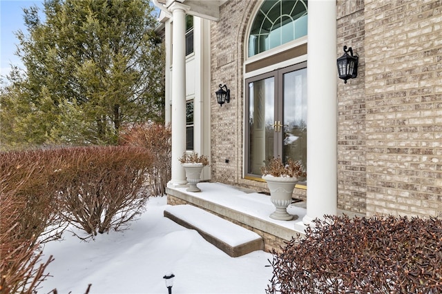 snow covered property entrance with french doors