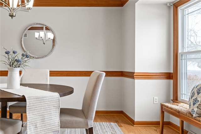 dining space with light wood-type flooring and a notable chandelier