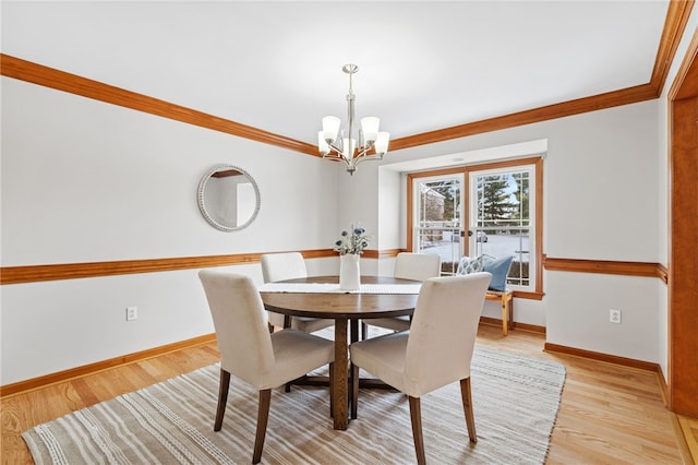 dining area with crown molding, a chandelier, and light hardwood / wood-style floors