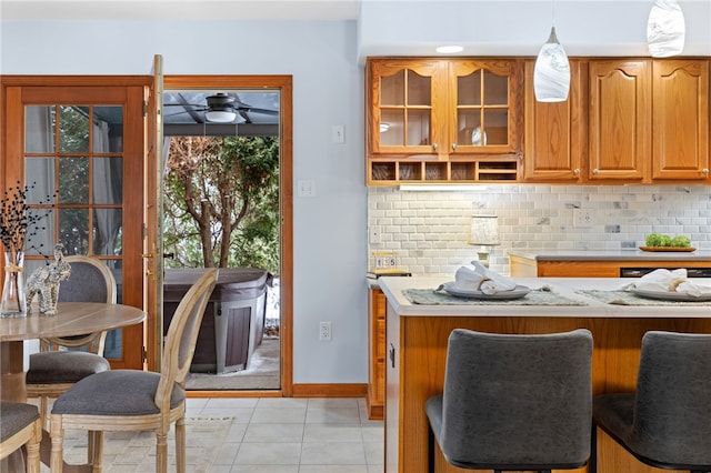 kitchen with ceiling fan, backsplash, kitchen peninsula, pendant lighting, and light tile patterned flooring