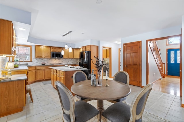 tiled dining space featuring washer / clothes dryer and sink