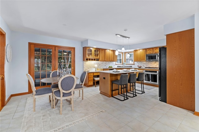 kitchen featuring tasteful backsplash, hanging light fixtures, a kitchen island, and stainless steel appliances