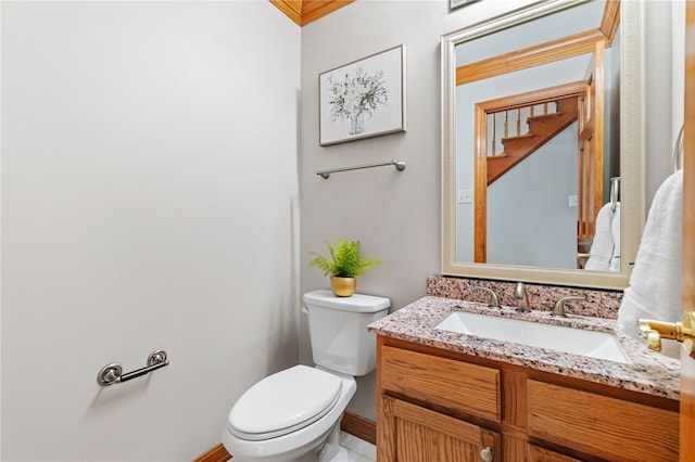 bathroom featuring vanity, toilet, and crown molding