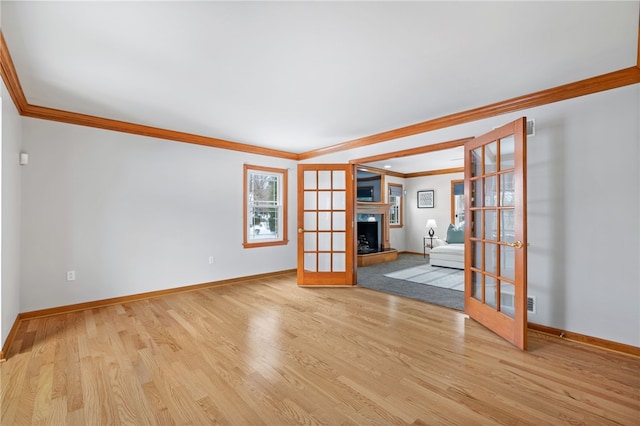 spare room with french doors, light wood-type flooring, and crown molding