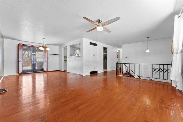 unfurnished living room featuring ceiling fan and wood-type flooring