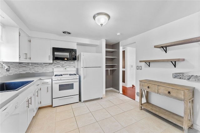 kitchen with sink, white cabinets, light tile patterned flooring, and white appliances