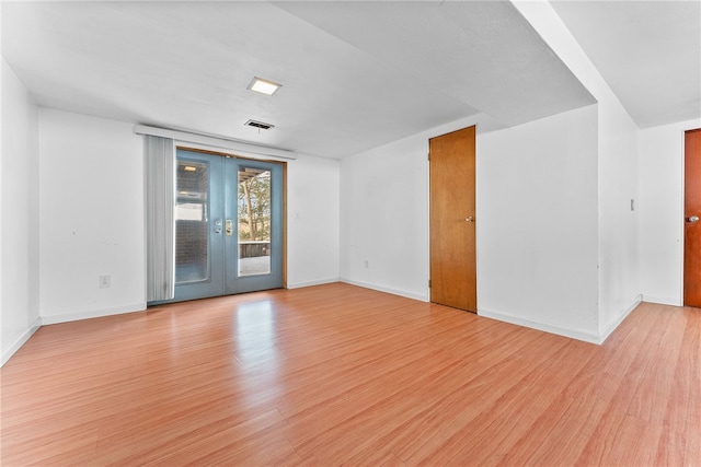 unfurnished room with french doors and light hardwood / wood-style flooring