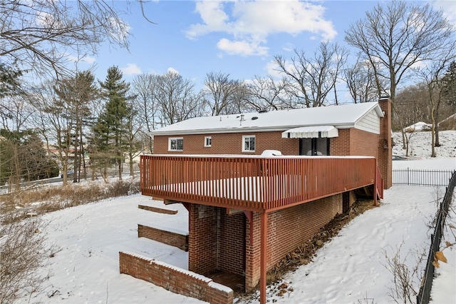 snow covered house featuring a deck