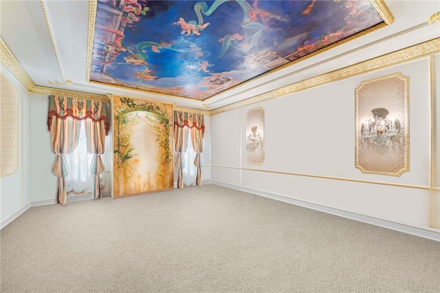 carpeted empty room featuring a raised ceiling and ornamental molding