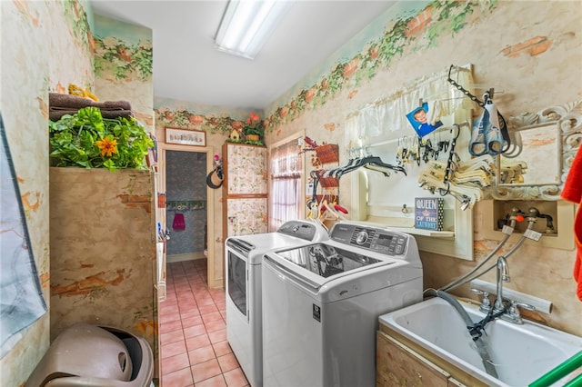 laundry room with washing machine and clothes dryer, sink, and light tile patterned flooring